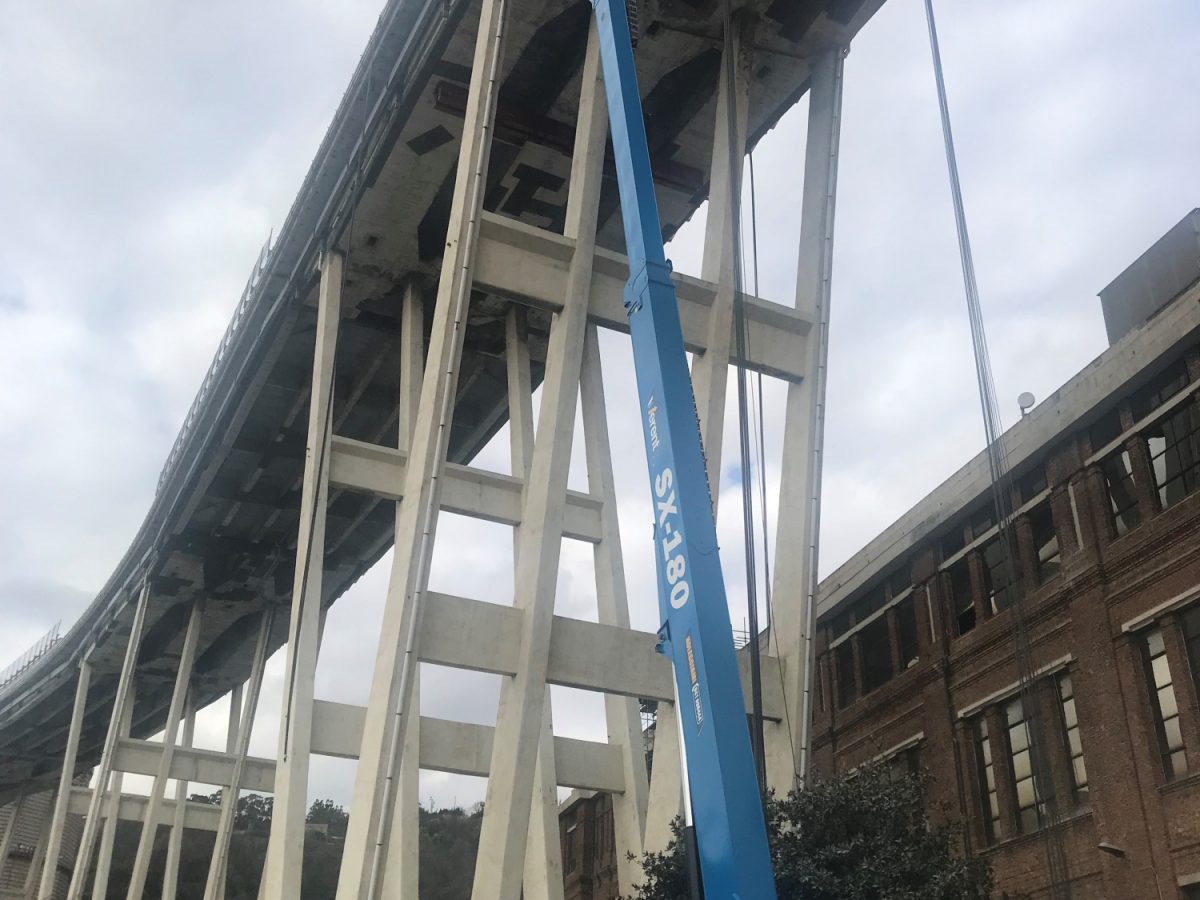 Two Genie SX-180 boom lifts involved in a high-precision demolition process in Italy