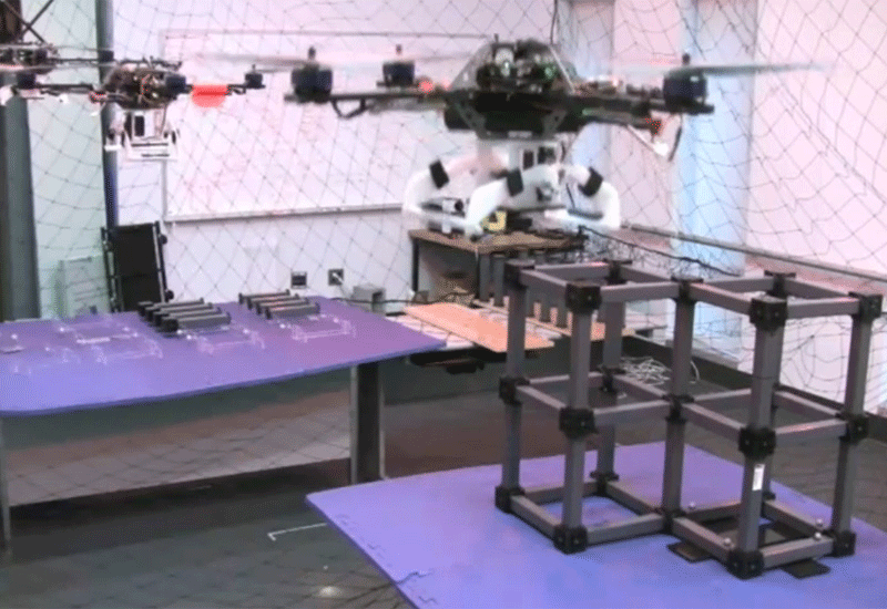 Flying robot drones build scale model structure